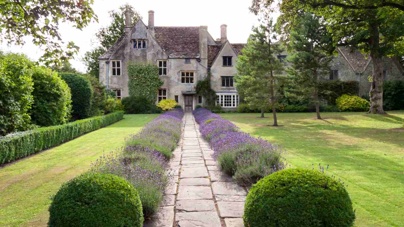 Stately house with long garden path decorated with lavender either side