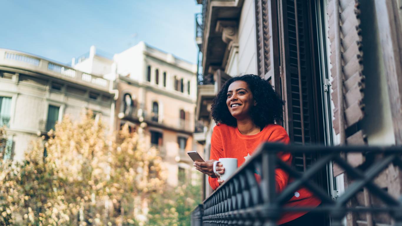 Lady drinking a tea looking out over a balcony